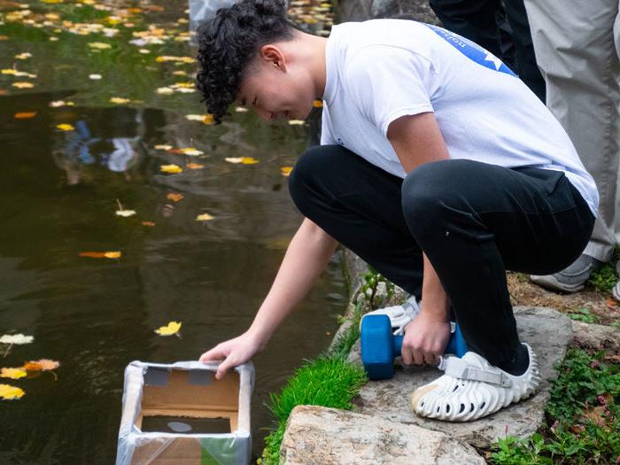 学生正在测试纸板帆船赛的原型船